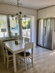 FälhultにあるSmåländsk stugidyll med vedeldad tunna & pizzaugnの白いテーブルと冷蔵庫のあるキッチン