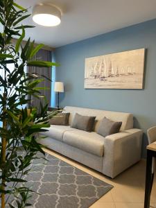 a living room with a couch and sailboats on the wall at Apartment Belaj SeaSide Resort - Sea view in Umag