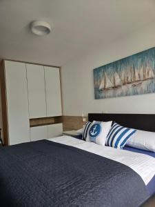 a bedroom with a large bed and a painting on the wall at Apartment Belaj SeaSide Resort - Sea view in Umag