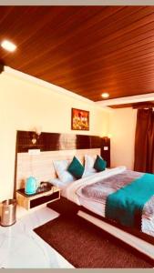 a bedroom with a large bed with green pillows at Hotel New Urvashi in Jāmb