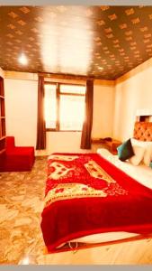 a bedroom with a red bed and a window at Hotel New Urvashi in Jāmb +4 photos