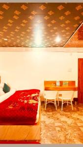a bedroom with a bed and a table with chairs at Hotel New Urvashi in Jāmb
