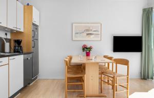 une cuisine et une salle à manger avec une table et des chaises dans l'établissement Gudhjem Søpark Lejl 22, à Gudhjem