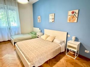 een blauwe slaapkamer met een bed en een raam bij Como city apartment Giulio Cesare in Como