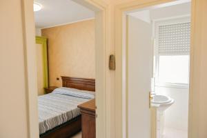 1 dormitorio con cama, lavabo y ventana en 7 posti nel cuore dell'area pedonale con parcheggio, en Bibione