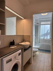 a bathroom with a washing machine and a sink at Appartamenti TEI Orobic Experience in Premana +137 photos