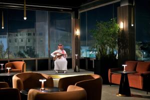 a man standing on a stage with a guitar at Al Ahsa InterContinental by IHG in Al Ahsa