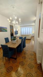 a dining room table with blue chairs and a chandelier at La Residenza del Cavallino Affittacamere in Fermo