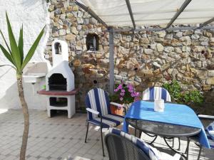 a patio with a table and chairs and a stone oven at Le Case dei pescatori - Sirena in Arcipelago Ponziano