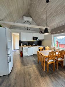a kitchen and dining room with a table and chairs at Lille huset in Holmestrand