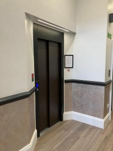 un ascenseur dans un immeuble avec une porte noire dans l'établissement MSK Elite, à Londres