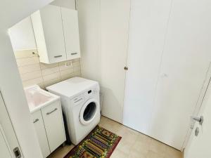 a laundry room with a washing machine and a washer at La casa di Tina in Pachino +51 photos