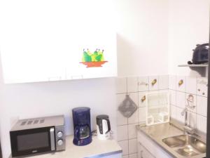 a kitchen with a microwave and a sink at Küstenlounge Dornumersiel in Dornum