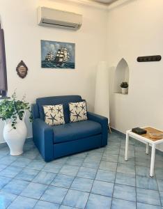 a living room with a blue couch and a table at Casa Tasca in Ravello