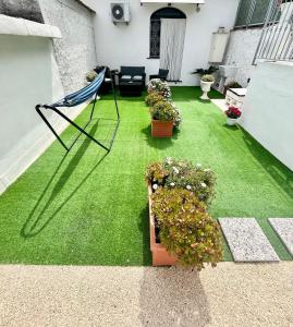a patio with green grass and a chair and potted plants at Casa Tasca in Ravello +12 photos