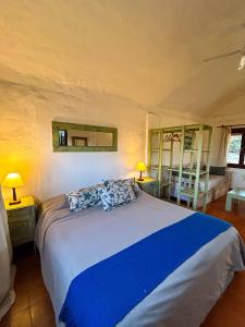 a bedroom with a large bed with a blue blanket at Posada Buen Camino in Nono +42 photos
