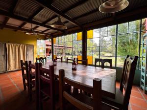 a dining room with a large wooden table and chairs at Posada Buen Camino in Nono