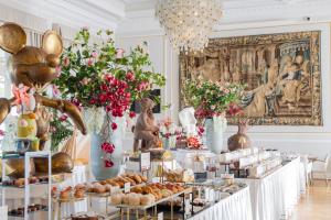a buffet of food in a room with flowers at Grand Hotel Principe Di Piemonte in Viareggio