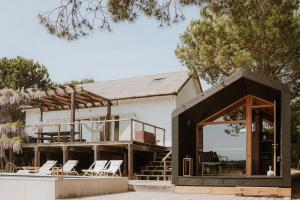a house with a large glass door and chairs at Precious Cabin in Comporta in Comporta