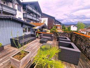 a patio with chairs and plants on a wooden deck at Pension Landhaus Koller - Adults only in Bodenmais