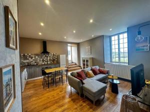 ein Wohnzimmer mit Sofa und Tisch in der Unterkunft Maison confortable à Saint-Pierre-du-Mont avec jardin in Saint-Pierre-du-Mont