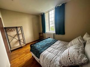 ein Schlafzimmer mit einem Bett und einem Fenster in der Unterkunft Maison confortable à Saint-Pierre-du-Mont avec jardin in Saint-Pierre-du-Mont