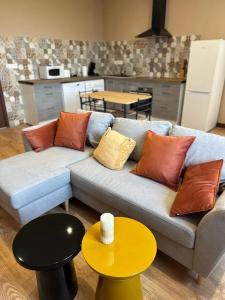 ein Wohnzimmer mit Sofa und Tisch in der Unterkunft Maison confortable à Saint-Pierre-du-Mont avec jardin in Saint-Pierre-du-Mont