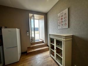 eine Küche mit Kühlschrank und einem Fenster in einem Zimmer in der Unterkunft Maison confortable à Saint-Pierre-du-Mont avec jardin in Saint-Pierre-du-Mont + 22 Fotos