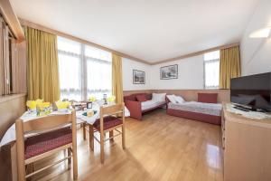 a living room with a couch and a table at Residence Villa al Sole in Selva di Val Gardena