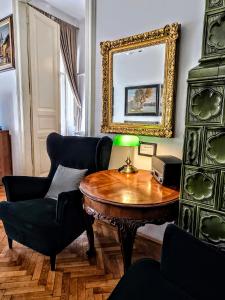 a living room with a table and chairs and a mirror at Christoph's Central Apartment in Budapest