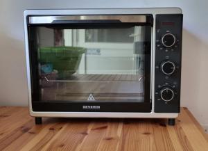 a microwave oven sitting on top of a wooden floor at Siófok - a nice little house in the green in Siófok