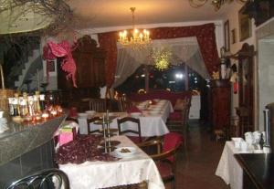 a restaurant with tables and chairs and a chandelier at Usługi hotelarskie Karpacz in Karpacz