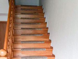 una escalera con escaleras de madera y barandilla en Ferienwohnung Mittermayer, en Ribnitz-Damgarten 2 fotos más