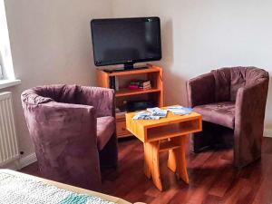 Una sala de estar con dos sillas y un televisor. en Ferienwohnung Mittermayer, en Ribnitz-Damgarten