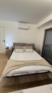 a large bed in a white room with a window at Apartment at the Beach in Aveiro +11 photos
