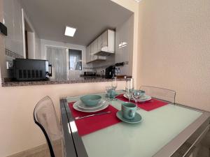 a dining room table with plates and glasses on it at Playa Albir Apartments in Albir