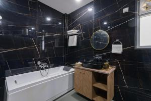 a bathroom with a bath tub and a sink at ELIVAAS AdhiVa 5-BHK Farmhouse with Private Pool, Bar & Lush Garden in Bahora