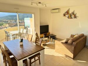 ein Wohnzimmer mit Sofa und Tisch in der Unterkunft Bel appartement vue mer-montagne in Calvi + 5 Fotos