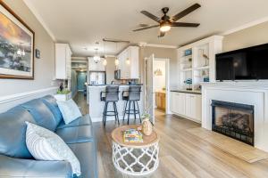 a living room with a blue couch and a fireplace at Smith Mountain Lake Retreat with Resort Amenities! in Huddleston