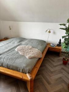 1 dormitorio con cama de madera y maceta en Wohnung mit Kahnstelle, en Maasholm
