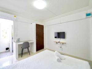 a bedroom with a bed and a desk and a television at RQ Suvarnabhumi Airport by Collection O in Bangkok