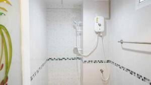 a bathroom with a shower with a phone on the wall at RQ Suvarnabhumi Airport by Collection O in Bangkok +17 photos