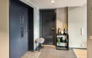 a hallway with a black door and a stool at 2 Bedroom Awesome Apartment In Sjusjøen in Sjusjøen +3 photos