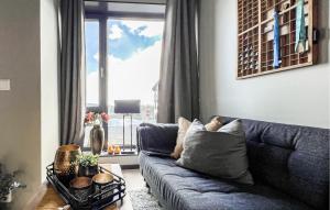 a living room with a blue couch and a window at 2 Bedroom Awesome Apartment In Sjusjøen in Sjusjøen