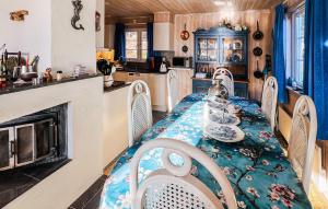 a kitchen with a table and chairs and a fireplace at 5 Bedroom Lovely Home In Tanumshede in Tanumshede