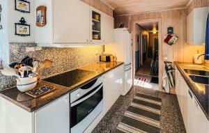 a kitchen with white cabinets and granite counter tops at 5 Bedroom Lovely Home In Tanumshede in Tanumshede