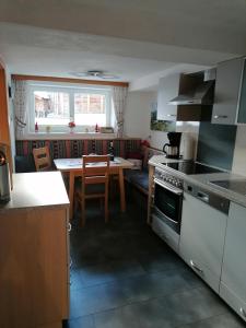 a kitchen with a table and a stove top oven at Hänsler's Hof in Arzl im Pitztal +21 photos