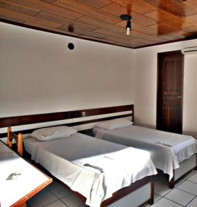 a room with two beds and a table in it at Hotel Subaé in Feira de Santana