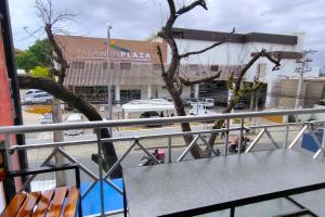 a table and chairs on a balcony with a building at Inn Ka Kay Mame Puerto Princesa in Puerto Princesa City