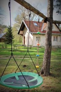 a swing in front of a tree with a house at PIZUNY Dom pod dębem z balią na wyłączność in Łukawica +68 photos